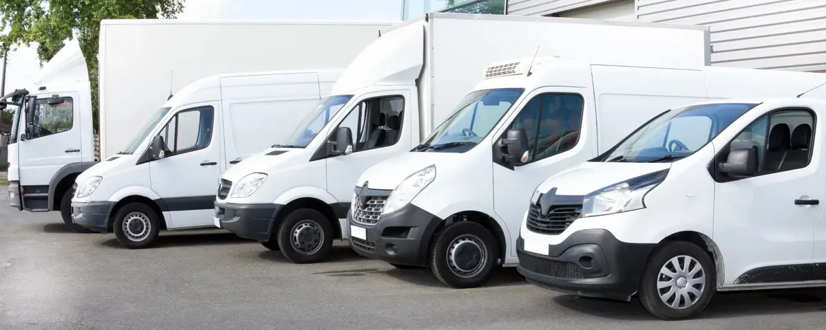 Flotte de véhicules utilitaires et de camions porteurs blancs, dont un camion frigorifique