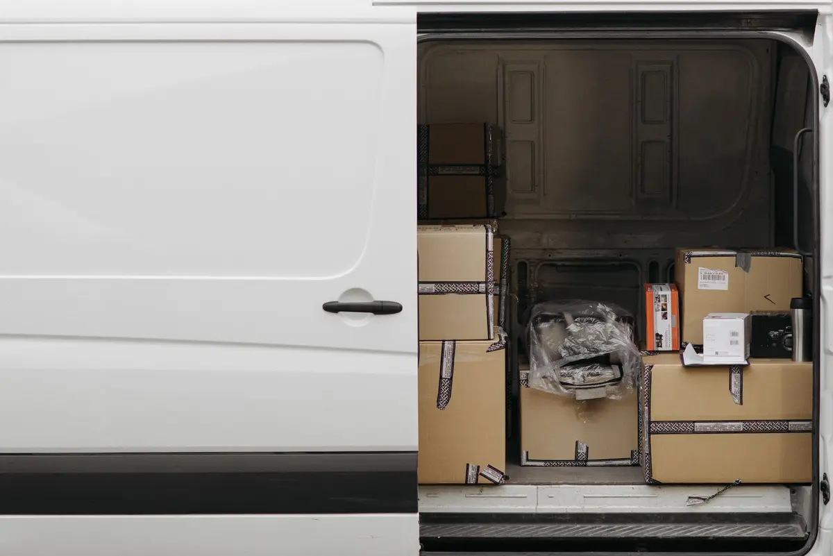 Utilitaire aux portes ouvertes, chargé de cartons arrimés